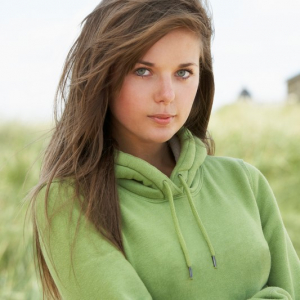 En bild på en kvinna i en grön ekologisk hoodtröja